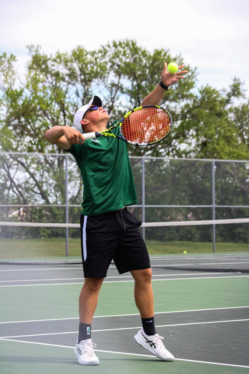 Player gets ready to throw the ball up in the air to serve. 