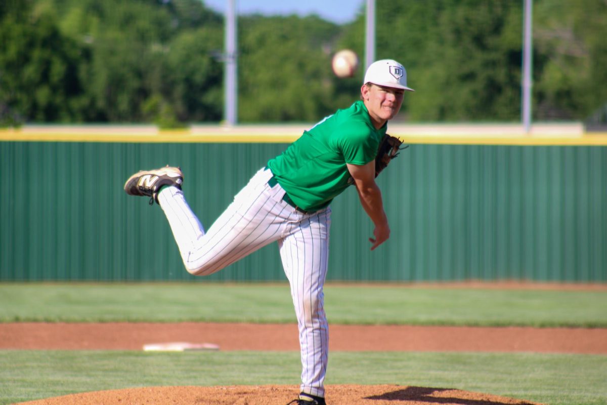 While pitching, Junior Noah DeVault throws ball.