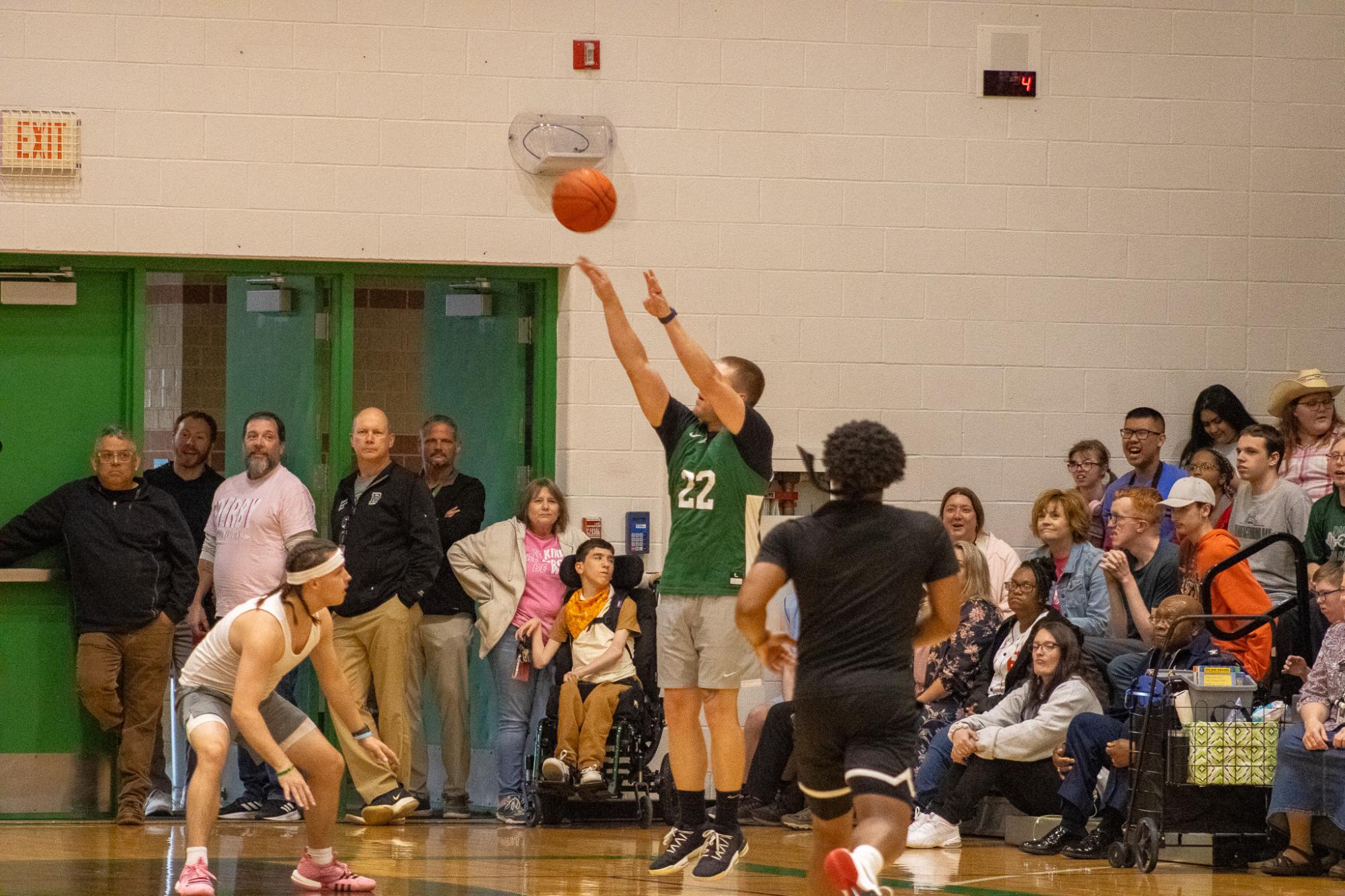 Staff shoots a three pointer.