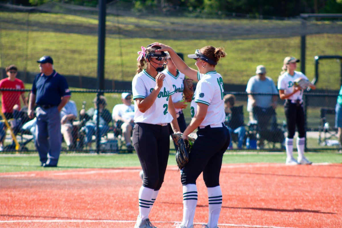 Softball players interact during game.