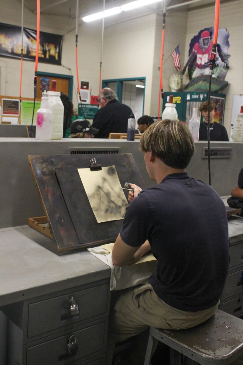Student practices airbrush.