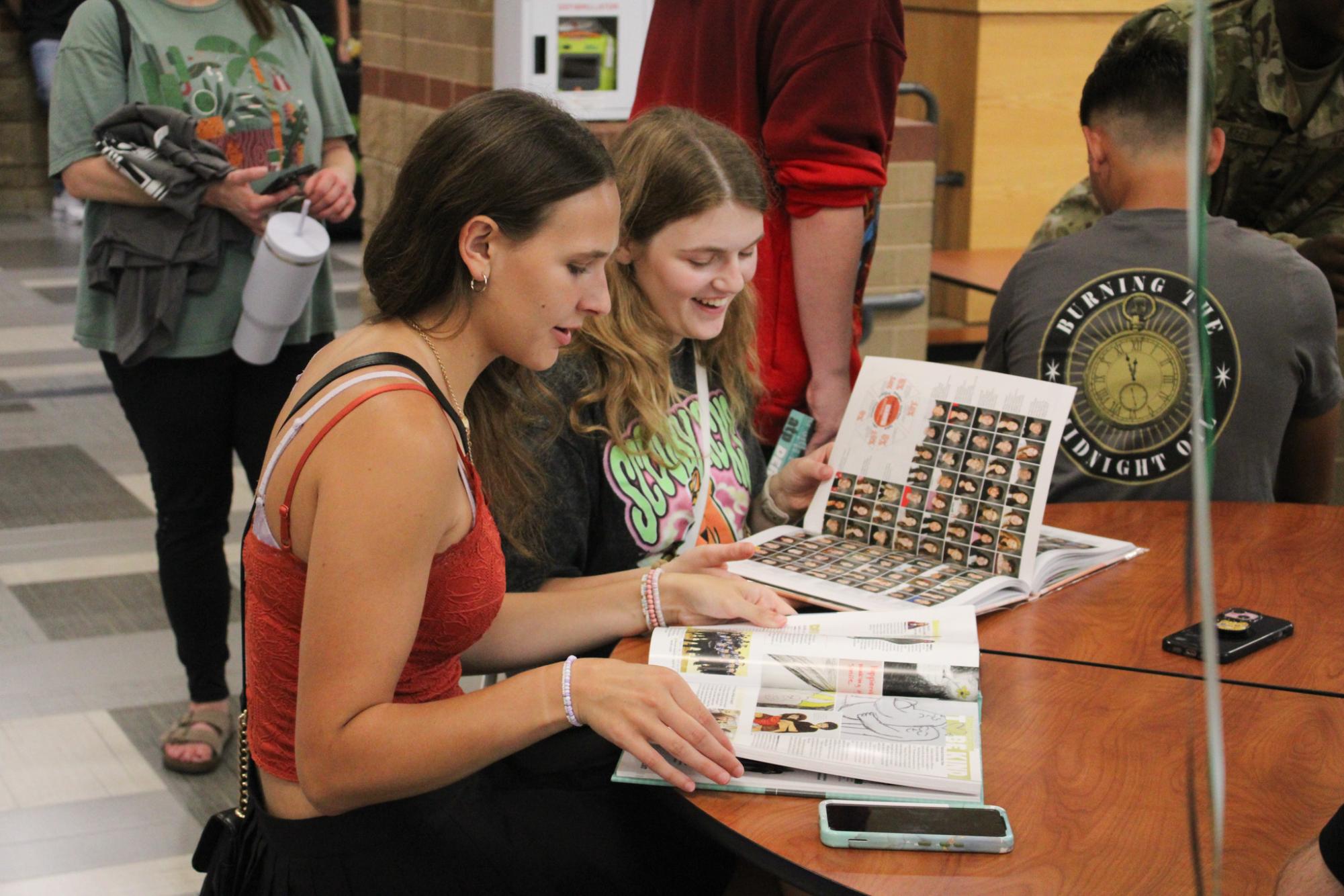 Students look through yearbook. 