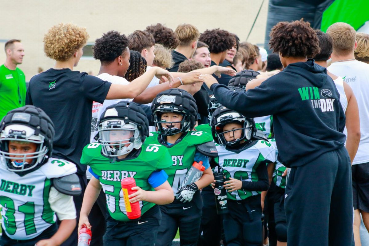 Junior Footballers run through tunnel of DHS Football players.