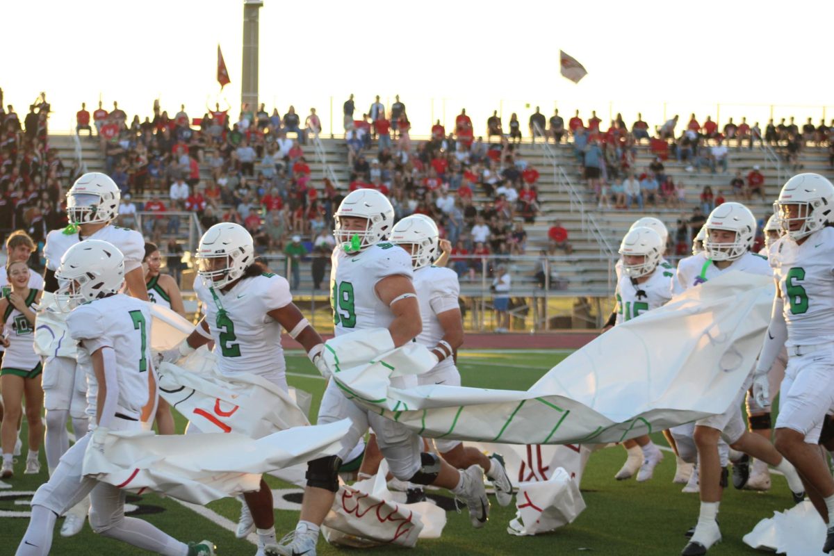 Football team runs through signs