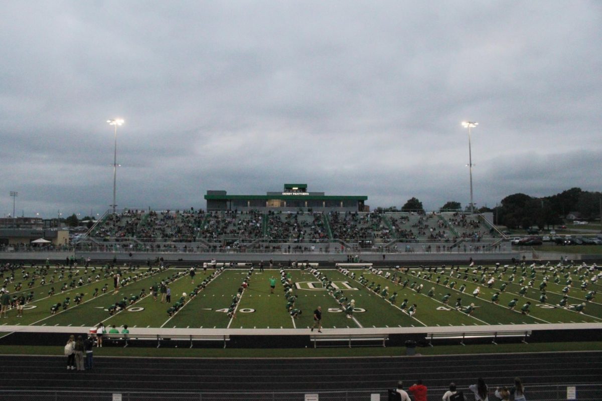 All football players do exercises on the field. 