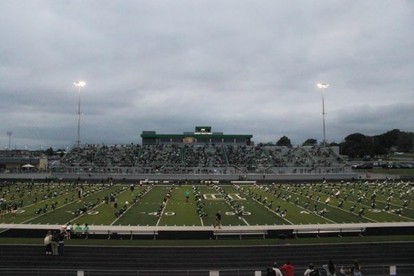 All football players do exercises on the field. 