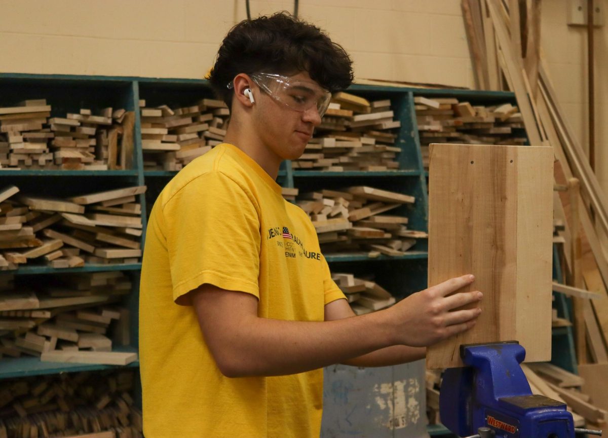 Student puts wood in clamp.