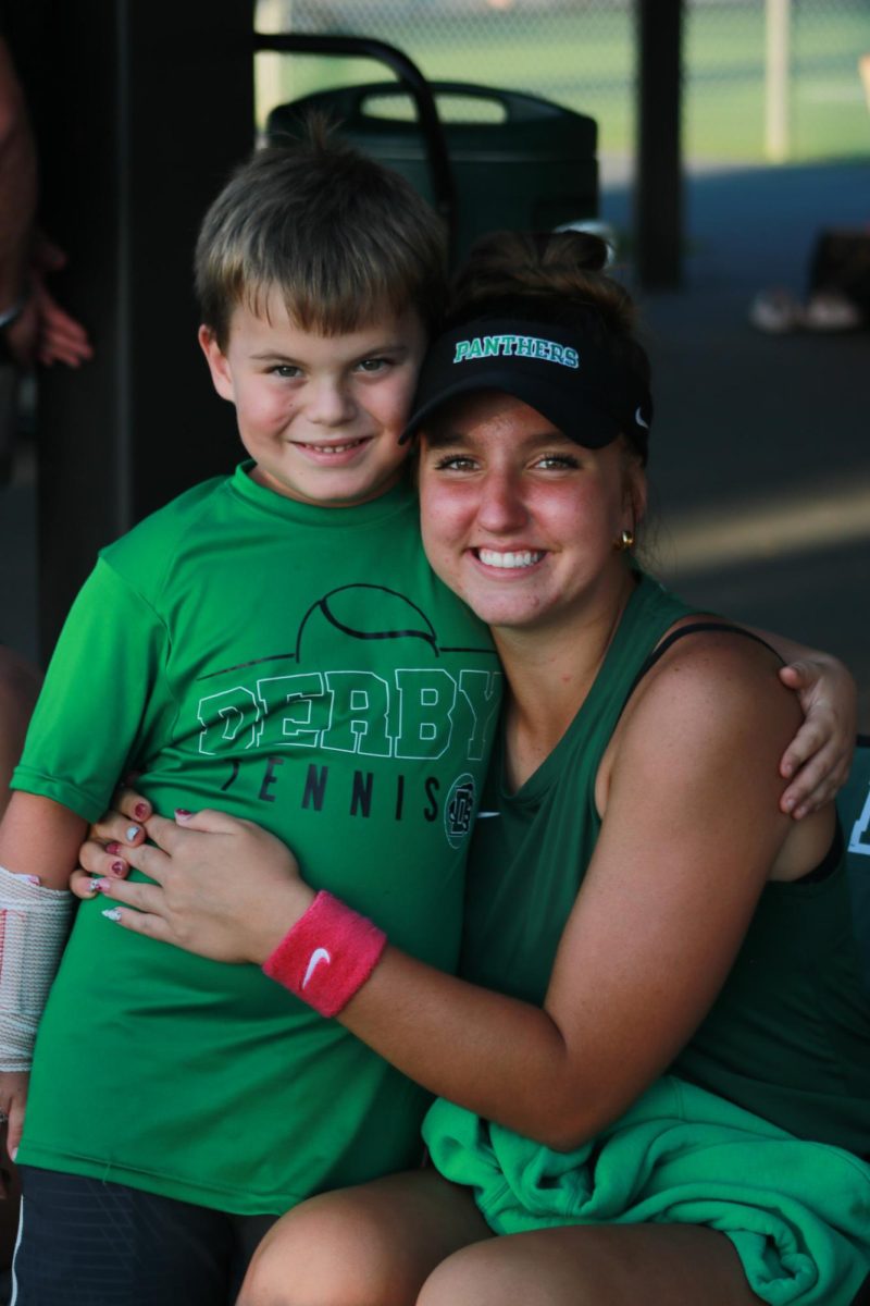 Senior Karlie Demel poses for a photo with a young kid.