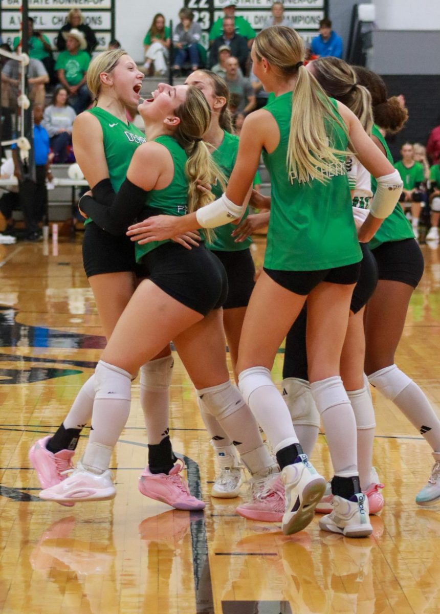 Volleyball players celebrate after winning point.