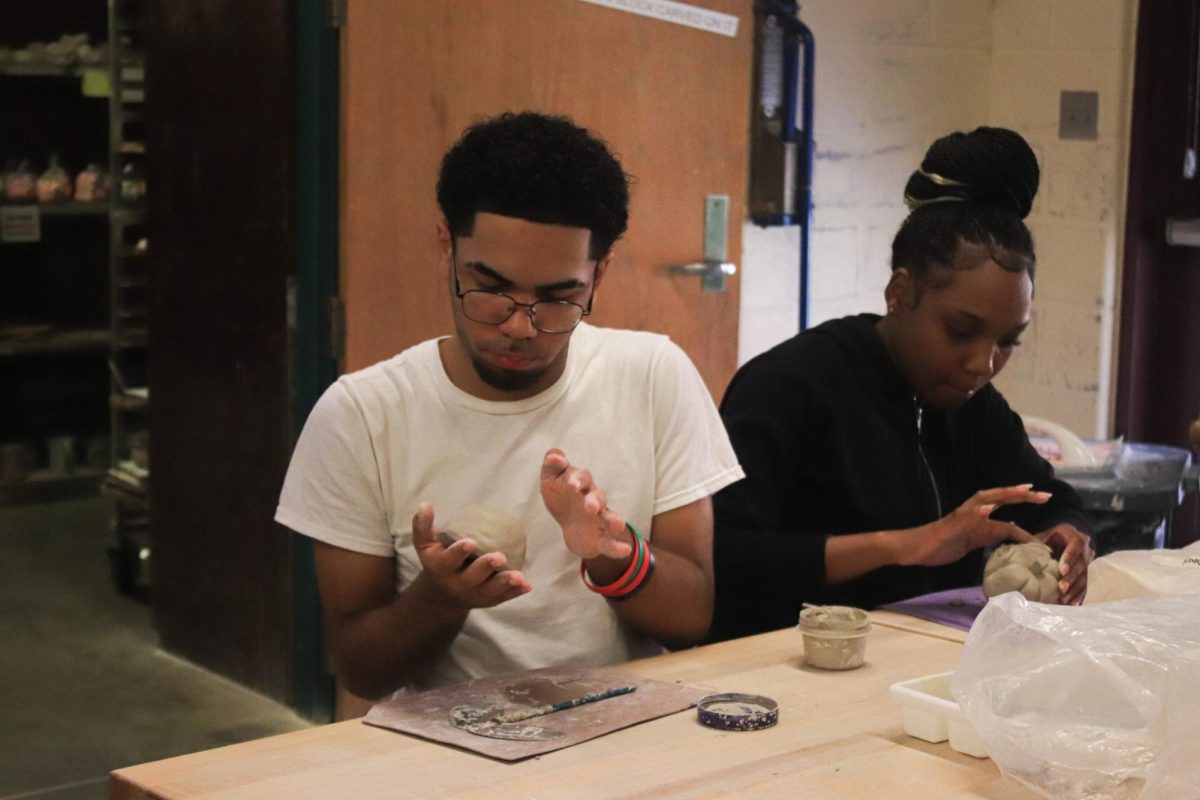 Student rolls clay into a sphere.