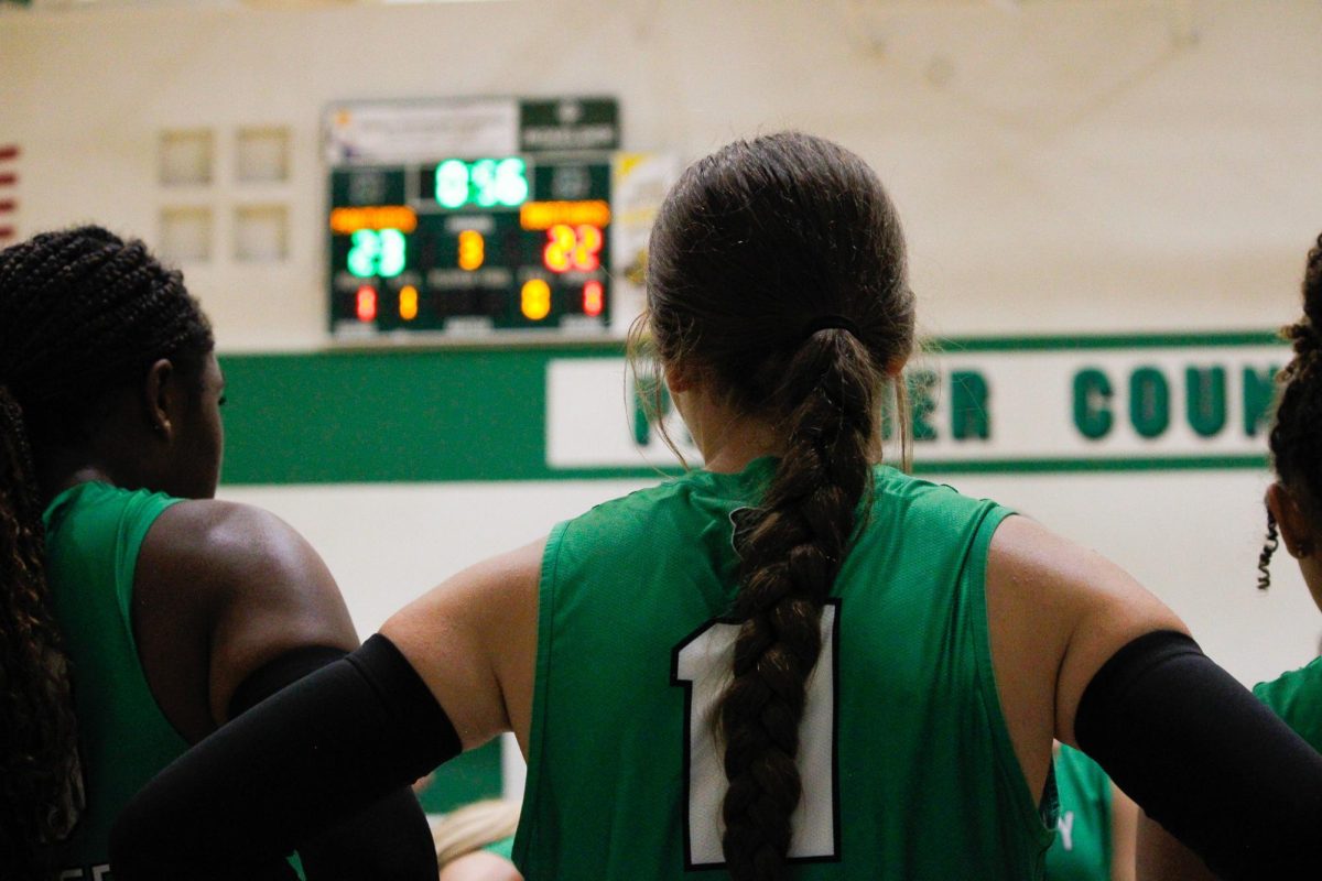 Junior Kelby Clingan stands in the timeout circle with the scoreboard behind her.