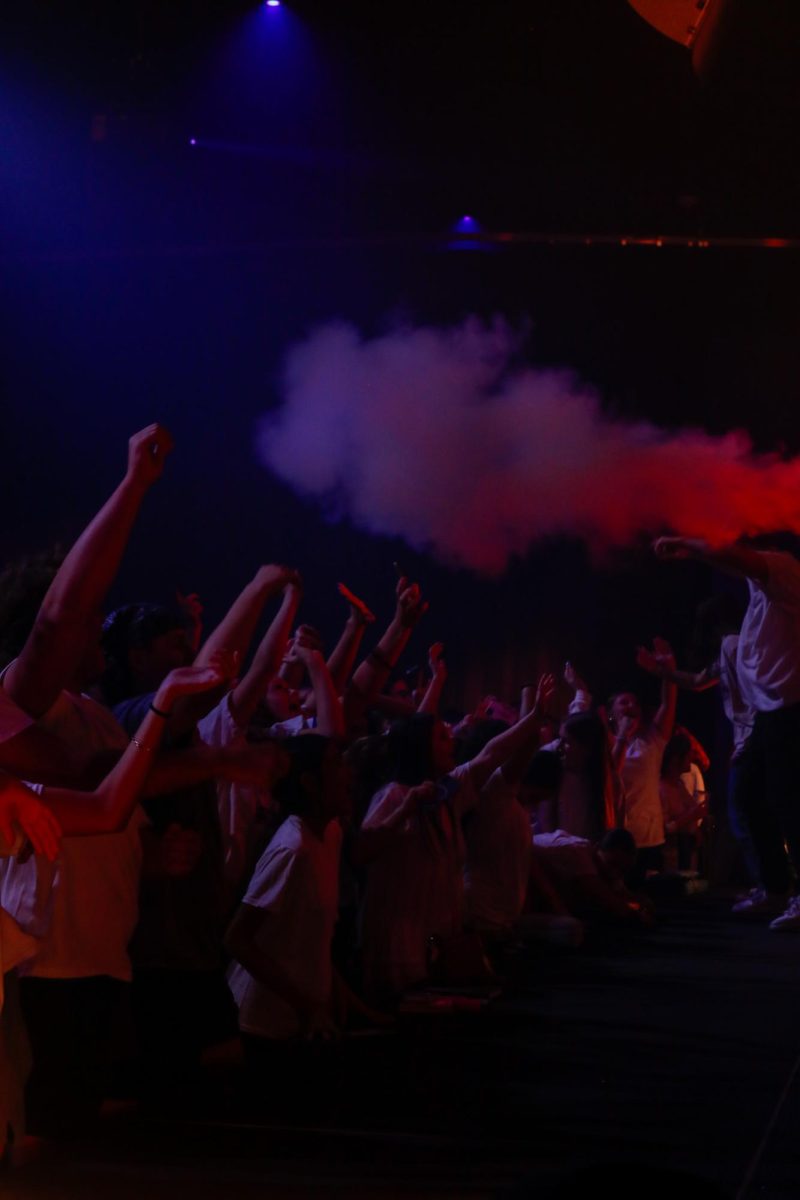 People sing and raise their hands in worship. 