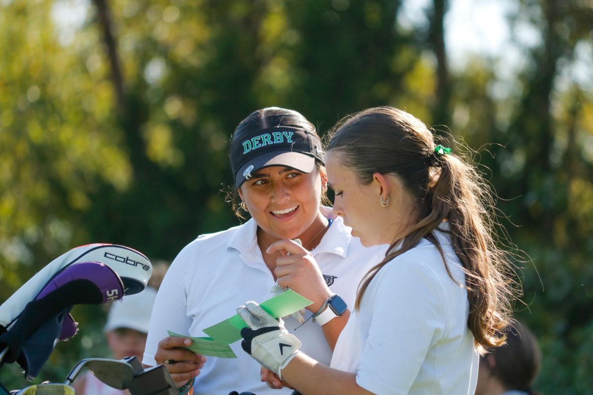 Golf players talk as they look at their scores.