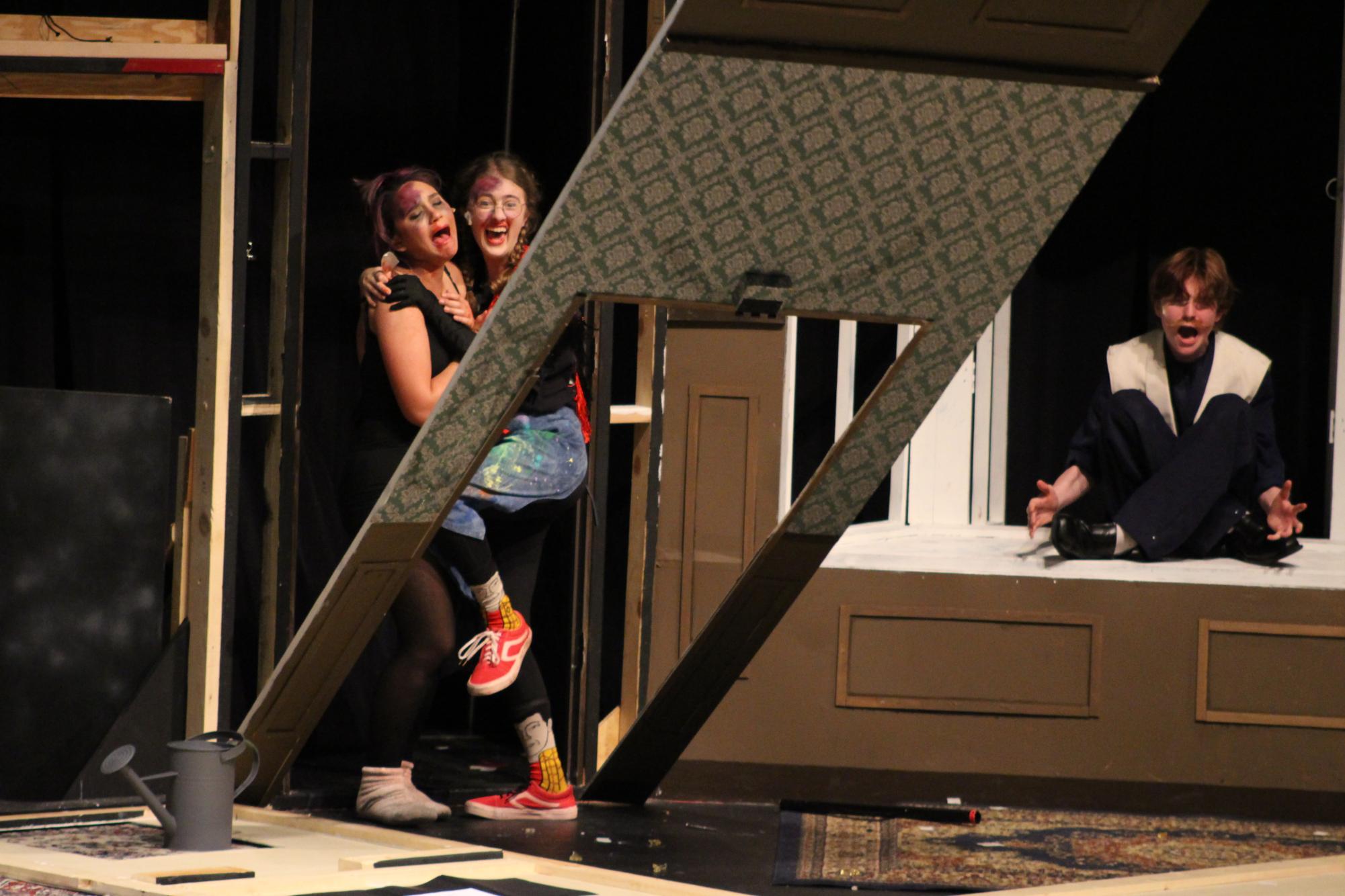 Background drop falling to ground while two actresses stand and watch