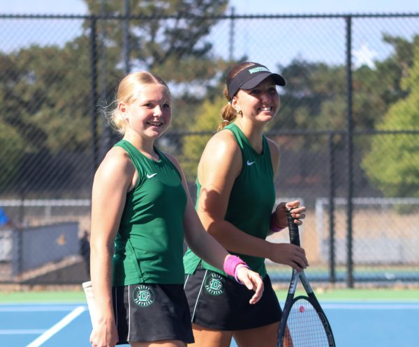 Tennis players laugh during break.