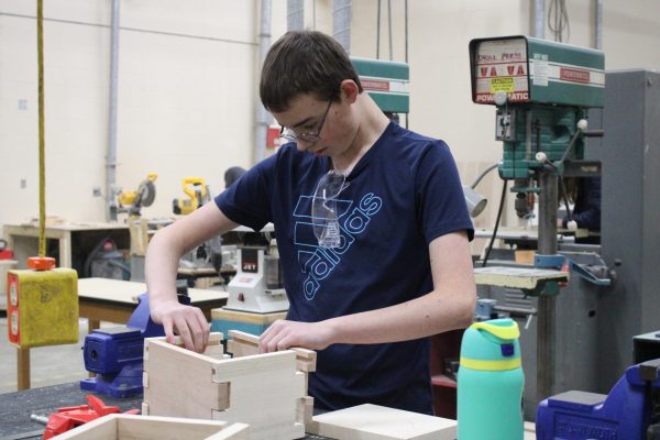 Student assembles the walls to a box.