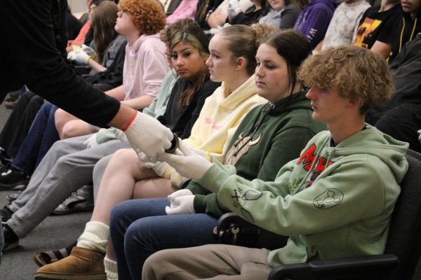 Student gets handed artifact from teacher.