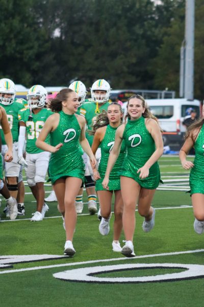 Dancers jumping up and down to hype the football team before game