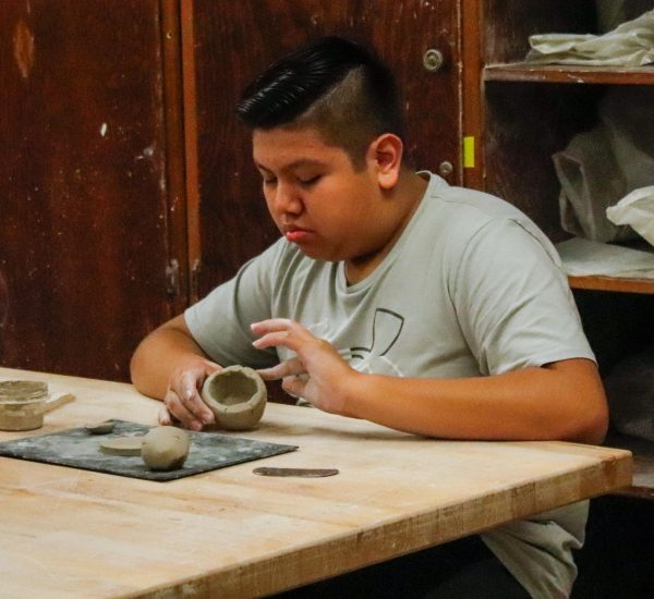 Student works on smoothing out the clay.