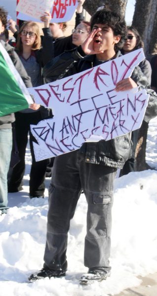 Student yells with sign outside the school.