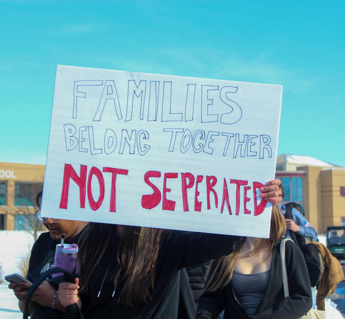 Student holds up sign to protest ICE. 