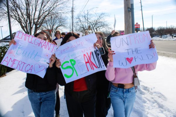 Students hold up signs. 