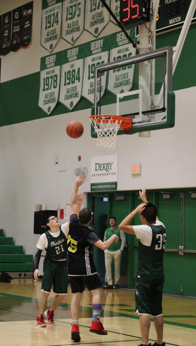 Opposing players attempt a lay up while being blocked. 
