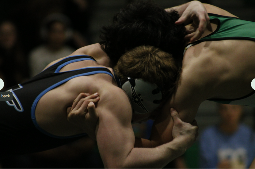 Wrestler grabs onto opponent. 