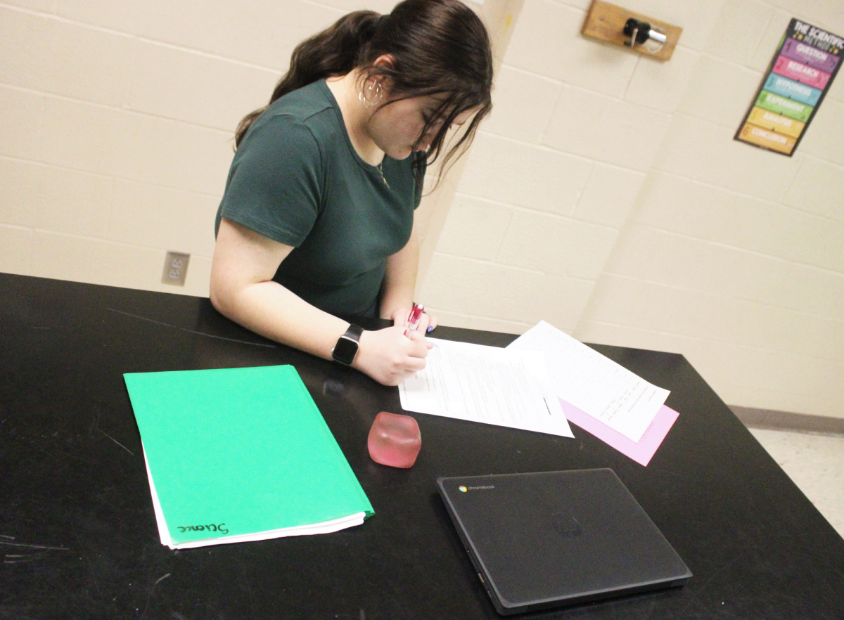 Student studying and taking notes during class.