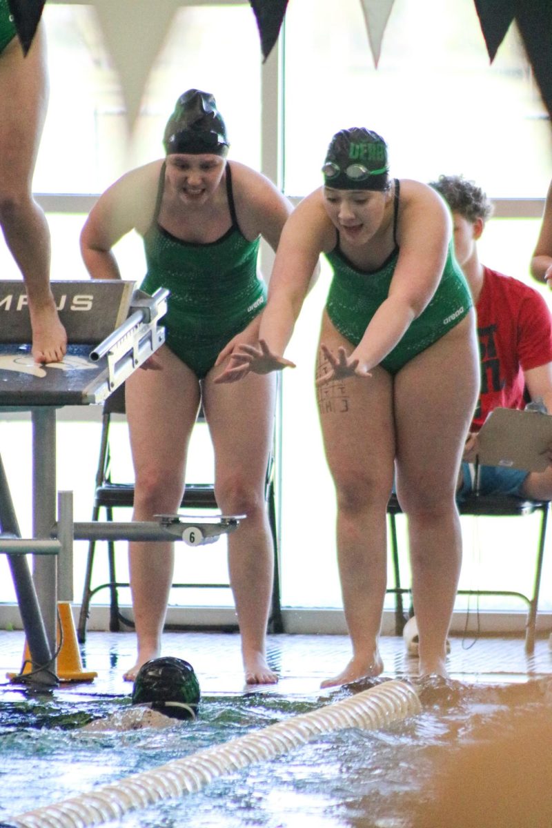 Swimmers cheer on teammate. 