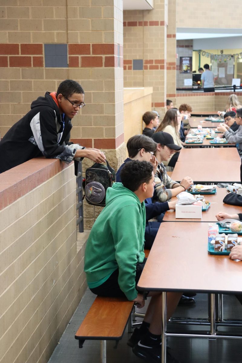 Students sit and talk at lunch.
