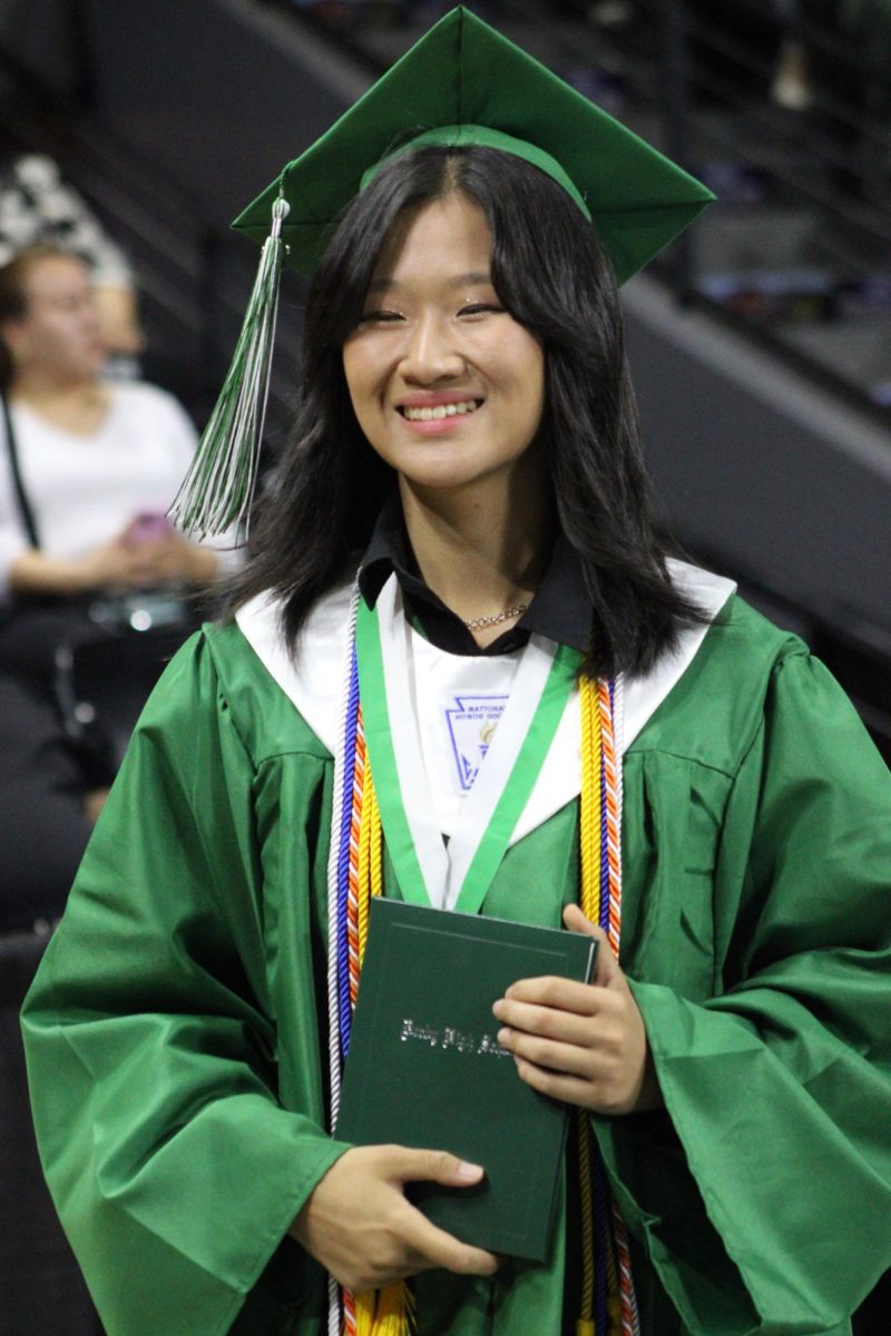 Student poses holding diploma.