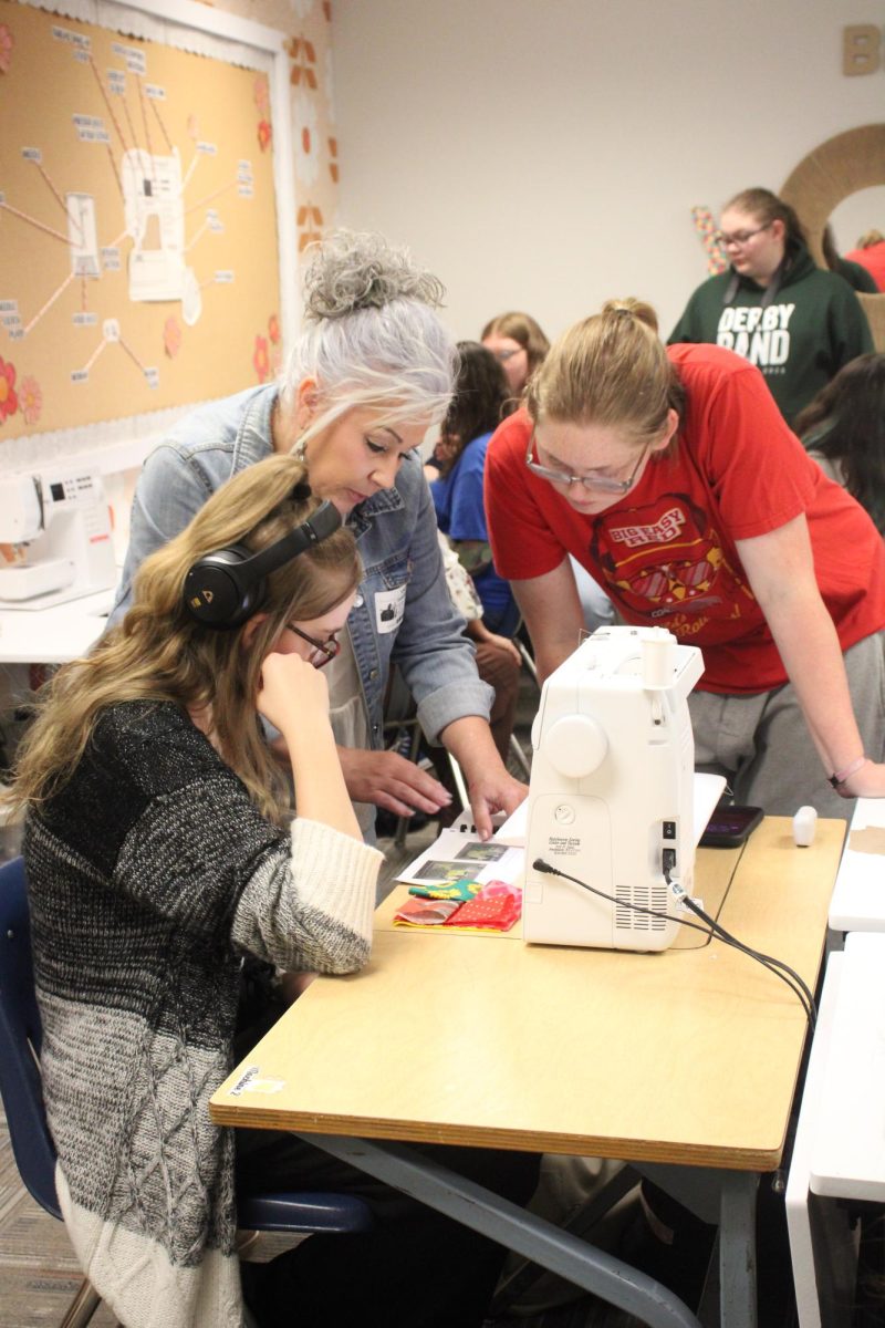 Student (far left) and company look over the instructions for their project.